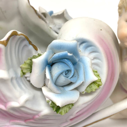 Porcelain Cherub Pushing a Seashell Wheelbarrow