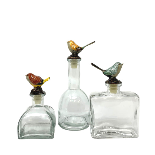 Set of Three Glass Bottles With Enameled Bird Stoppers
